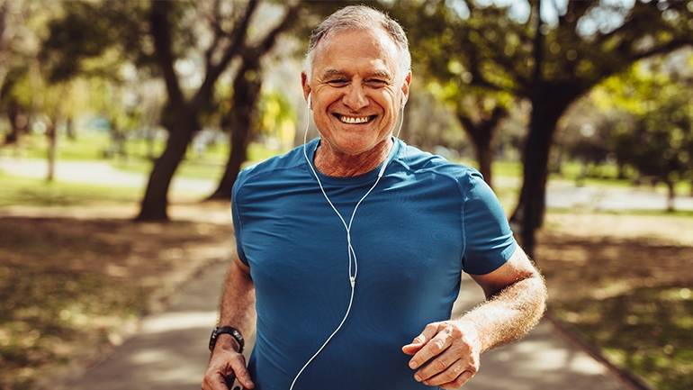 Ein Mann im blauem T-shirt ist in einem Park Joggen Ein Mann im blauem T-shirt ist in einem Park Joggen